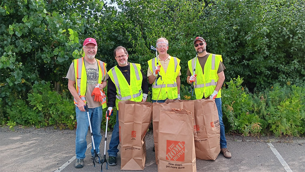 four pavek museum volunteers posing after a yard cleanup